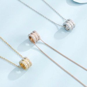 Three cylinder pendant necklaces in silver, gold, and rose gold with pavé zircon stones