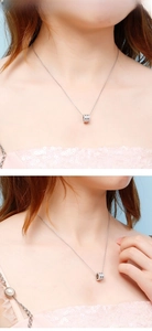 Detailed view of silver cylinder pendant with cubic zirconia stones on model