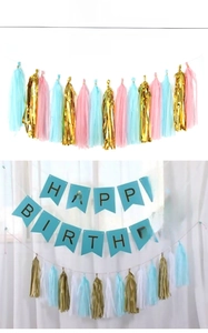 Détail d'une banderole Happy Birthday avec des pompons en papier pour décor de fête