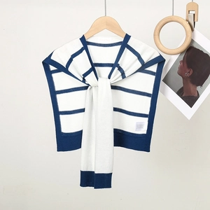 Chal de punto a rayas azules y blancas para mujer colgado en percha de madera