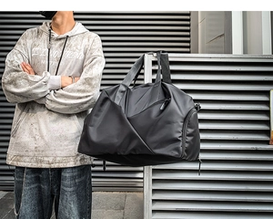 Model lifestyle view of the black nylon duffel bag for gym and outdoor travel