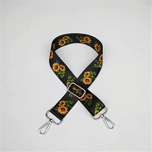 Detail of adjustable nylon strap with sunflower pattern and silver metal swivel hooks