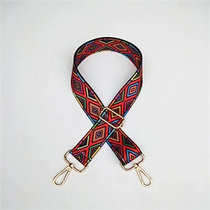 Close-up of ethnic style wide strap with colorful geometric patterns and gold metal hooks