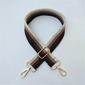 Detail of adjustable striped fabric bag strap with golden metal swivel hooks and buckle