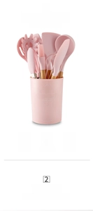 Dettaglio di 11 utensili da cucina in silicone rosa con manici in legno e secchiello porta