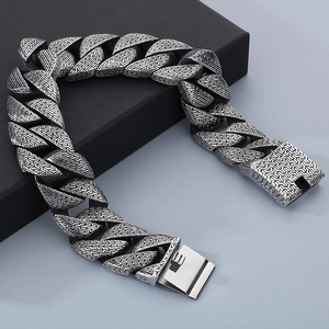 Close-up of vintage silver Cuban chain texture and square clasp on a metal bracelet
