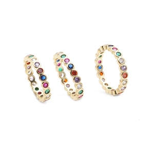 Detailed close-up of three gold stackable rings with multicolored zircon gemstones