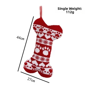 Detail of red and white knitted bone-shaped Christmas stocking with paw prints pattern