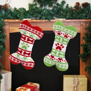 Festive knitted bone-shaped pet Christmas stockings with snowflakes on fireplace