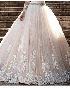 Détails d'appliqués en dentelle et ceinture de cristaux sur une robe de mariée