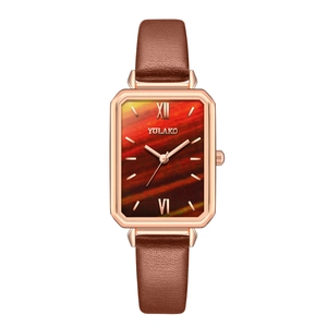 Rectangle rose gold watch with orange textured dial and brown leather strap on white background