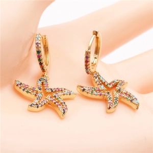 Golden starfish earrings with multi-color zircon stones held between fingers