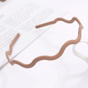 Matte coffee wavy headband with non-slip teeth displayed on a white cup handle