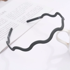 Macro detail of wave-shaped matte headband with anti-slip inner teeth in black finish