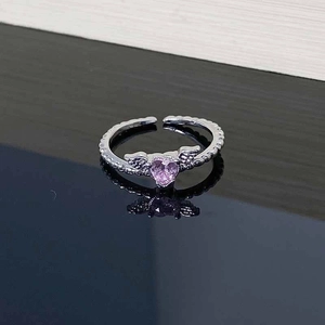 Macro detail of silver adjustable ring with pink heart zircon and angel wings design
