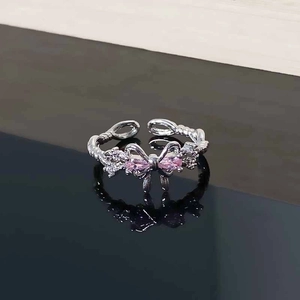 Detailed macro view of pink zircon bow-knot ring with silver twisted rope band