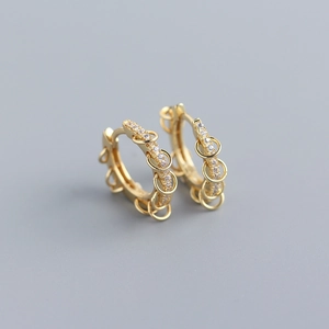Detailed macro of gold S925 silver hoop earrings with micro-pave zircons and moving rings