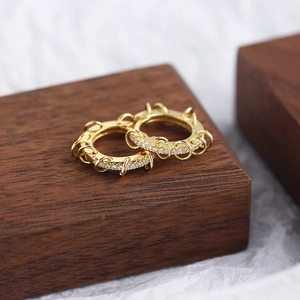 Macro detail of gold S925 sterling silver hoop earrings with sparkling zircon accents