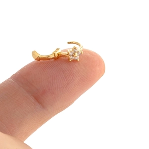 Delicate gold flower cartilage hoop earring with micro-paved cubic zirconia on fingertip