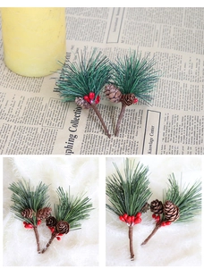 Detail of artificial pine needles with red berries and small pine cones for Christmas decor