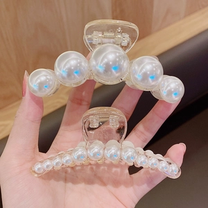 Detail of elegant pearl hair claw clips in large and small sizes with glossy finish