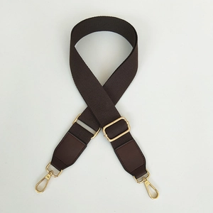 Detail of adjustable dark brown canvas strap with gold metal buckles and leather ends