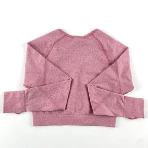 Dettaglio del top da yoga senza cuciture rosa con polsini a costine e maniche raglan