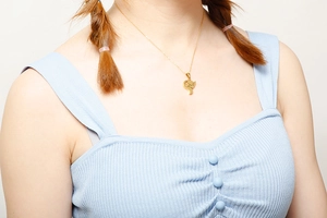 Close-up of model wearing a delicate gold heart pendant necklace with elegant finish