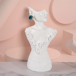 Detailed view of white resin bust jewelry stand showing blue earring display on marble