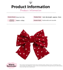 Detail view of a large 18cm red and white polka dot bow hair clip with alloy fastener
