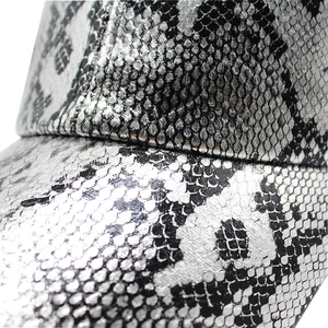 Macro shot of silver faux snake-skin texture on metallic baseball cap with scale pattern