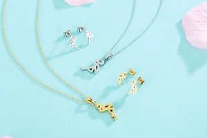 Flat lay of pink flamingo pendant necklaces and stud earrings set in gold and silver finish