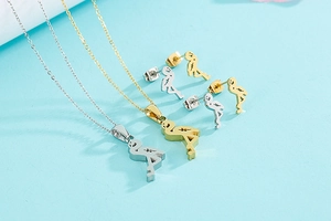 Close-up of flamingo pendant necklace and stud earrings set in gold and silver finishes