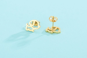 Détail rapproché des boucles d'oreilles tête de chiot creuse en finition dorée