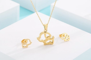 Détail du parure collier et boucles d'oreilles chien évidé doré sur supports blancs