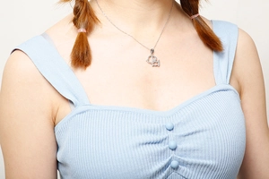 Gros plan d'un collier avec pendentif animal argenté porté par un mannequin