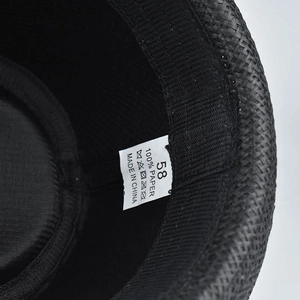 Detailed macro view of 100% paper fiber material and care label on the woven fedora hat