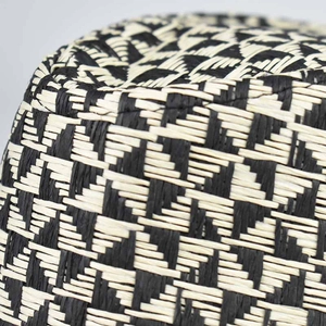 Detailed close-up of the woven linen sun hat showing fine black and white geometric patterns