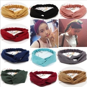 Close-up of wide yoga headbands in various colors featuring cross knot detail and elastic band