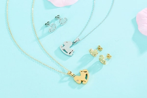 Dettaglio flat lay di collane e orecchini con cavallino a dondolo in oro e argento