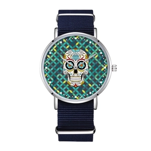 Macro shot of silver quartz watch featuring a green sugar skull dial and navy nylon strap