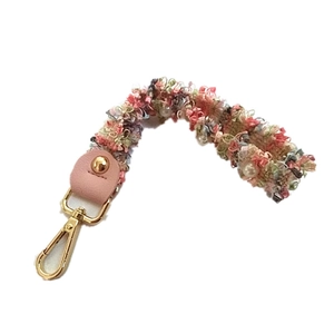 Short tweed purse strap with colorful pearls and gold metal clasp on white background