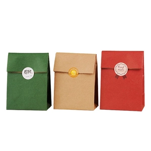 Close-up of colorful kraft gift bags in green, red, and brown with seal stickers