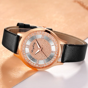 Close-up of rose gold watch case with rhinestone bezel and black leather strap detail