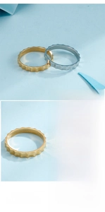 Detail showing wavy gear-shaped rings in gold and silver stainless steel minimalist style