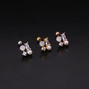 Close-up of stainless steel stud earrings in silver, gold, and rose gold with zircon