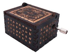 Close-up of vintage hand-cranked wooden music box with laser engraved floral patterns