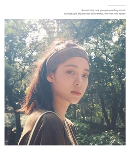 Outdoor shot of a wide grey elastic knitted headband worn by a model in nature