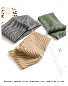 Close-up of ribbed knit headbands in grey, dark green, and khaki on a white surface
