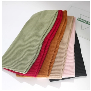Detail of ribbed knit beanies in multiple colors including green, red, beige and black